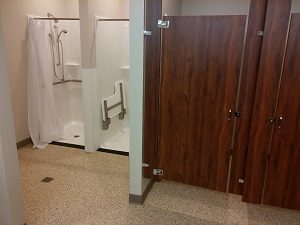 Accessible restroom with shower and grab bars for support.