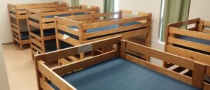 Wooden bunk beds with blue mattresses in a tidy room.