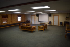 A quiet, wood-paneled meeting room with sofas and a projector screen.